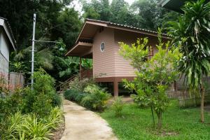 a small house in a garden with a sidewalk at Honey Home Pai in Pai