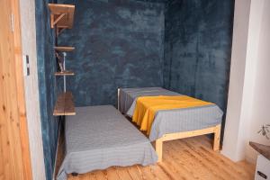 two beds in a room with a blue wall at 暮らす実験室 in Taketa