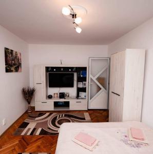 a living room with a television and a white cabinet at Mim's Home in Băile Herculane