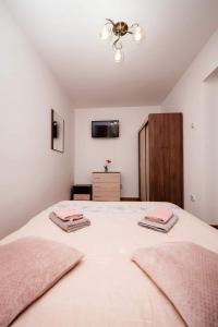 a bedroom with a large bed with two towels on it at Mim's Home in Băile Herculane
