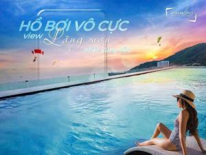 a woman sitting on a surfboard next to a swimming pool at Khác Sạn Oytes Bay in Xa Thang Nhi