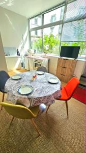 a dining room with a table with chairs and a tableablish at Appartement centre ville- cour- pkg proximité in Aurillac +8 photos
