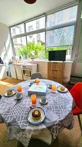 a table with plates of food and orange juice on it at Appartement centre ville- cour- pkg proximité in Aurillac
