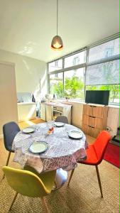 a room with a table and chairs and a kitchen at Appartement centre ville- cour- pkg proximité in Aurillac