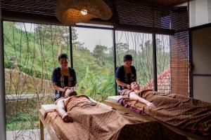 a group of people sitting on beds in a room at Munduk Tentrem Resort in Munduk