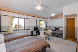 a hotel room with two beds and a desk and a table at Madarao Kogen Hotel in Iiyama +24 photos