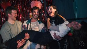 a group of people standing around a man holding a woman at UNPLAN Shinjuku in Tokyo