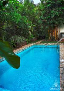 a large blue swimming pool with trees in the background at Aybo Soulscape Villa Dambulla in Dambulla