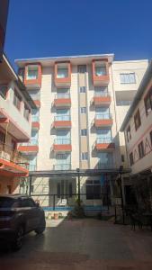 a large apartment building with a car parked in front of it at Hotel Central in Cochabamba
