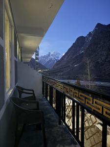 a balcony with chairs and a view of mountains at Julley Jispa in Jispa