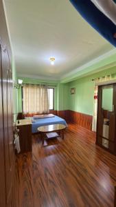 a bedroom with two beds and a wooden floor at Pharping StayInn in Pharping