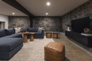 a living room with a blue couch and a tv at Lokis Loft and Cellar at the 1896 Building in Kaslo