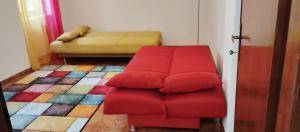 a red couch in a living room with a bed at A casa di Rita in Dunarobba