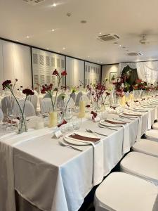 a row of tables with white table cloths and flowers at The Raweekanlaya Bangkok Wellness Cuisine Resort in Bangkok +112 photos
