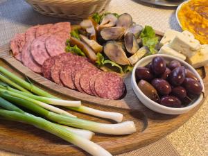 a cutting board with different types of meats and vegetables at Pestele Ca Odinioară in Murighiol