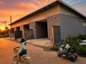 two children riding a bike next to a scooter at 786ResortSungaiGolok in Kampong Baka