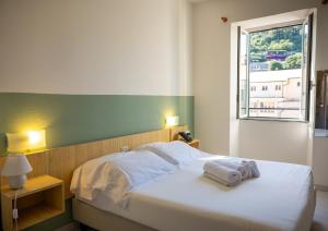 a bedroom with a bed with two towels on it at Hotel Miramare in Pietra Ligure