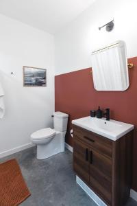 ein Badezimmer mit Toilette, Waschbecken und Spiegel in der Unterkunft The Brickworks at the 1896 Building in Kaslo + 30 Fotos