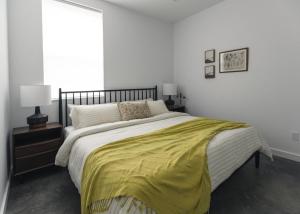 ein Schlafzimmer mit einem Bett, auf dem eine gelbe Decke liegt in der Unterkunft The Brickworks at the 1896 Building in Kaslo