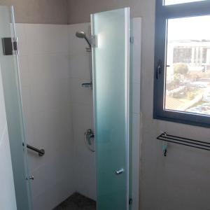 a shower with a glass door in a bathroom at Cozy modern apartment in Hadera in H̱adera +11 photos
