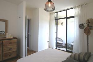 a bedroom with a bed and a sliding glass door at Cozy modern apartment in Hadera in H̱adera