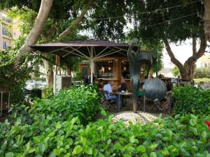 a statue of a person sitting at a table under an umbrella at Cozy modern apartment in Hadera in H̱adera