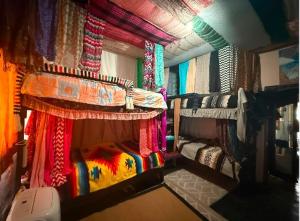 a room with two bunk beds with colorful curtains at My Little Hostel in Monterrey