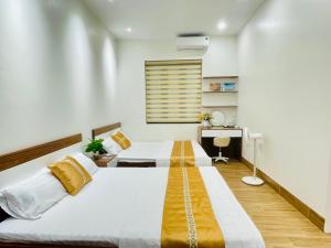 a bedroom with two beds and a desk at LanAnh homestay in Chung Cap