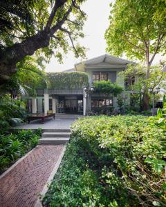 a house with a brick walkway in front of it at The Raweekanlaya Bangkok Wellness Cuisine Resort in Bangkok