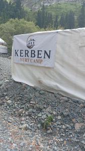 a white sign that saysken ut camp on a banner at Kerben yurt camp in Mineralʼnyy Istochnik Altyn-Arasan