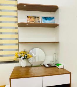 a dressing table with a mirror and a vase of flowers at LanAnh homestay in Chung Cap
