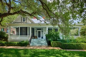 a white house with a front porch and stairs at Hotel Saint Cecilia in Austin