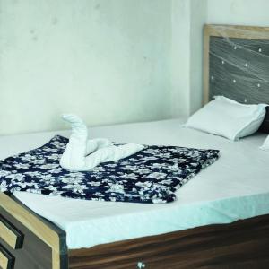 a bed with a black and white quilt on it at Shri om paradise inn in Mathura