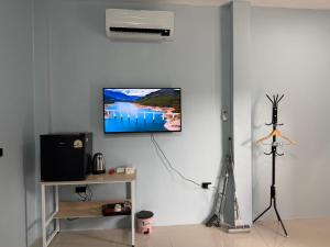 a living room with a tv on a white wall at 786ResortSungaiGolok in Kampong Baka