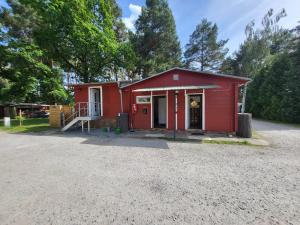 a red shed with a porch and a driveway at Wanderhütte Woody in Schwarzbach