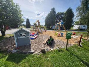a playground with a play set and a play house at Wanderhütte Woody in Schwarzbach +2 photos