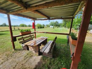 a wooden bench under a pavilion in a field at Wanderhütte Woody in Schwarzbach