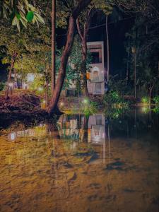 a flooded street in front of a house at night at Nilwadula Hotel Udawalawe in Ratkarawwa +98 photos