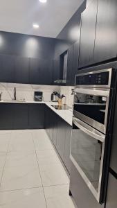 a kitchen with black and white cabinets and an oven at Greivin House in Santa María