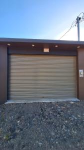 a garage with a large door on the side of a building at Greivin House in Santa María