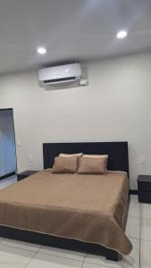 a bedroom with a large bed with a projector on the wall at Greivin House in Santa María