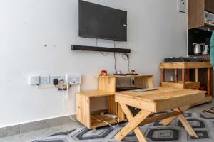 a room with a table and a television on a wall at Bellora Urban Homes in Ongata Rongai 