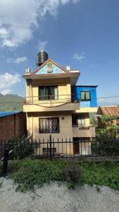 a yellow house with a fence in front of it at Satikhel StayInn in Pharping