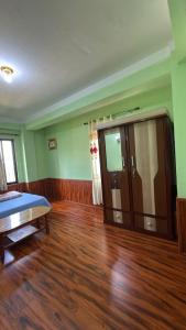 an empty room with a bed and a wooden floor at Satikhel StayInn in Pharping