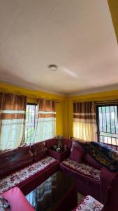 a living room with a couch and windows at Satikhel StayInn in Pharping