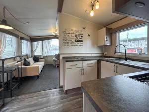 a kitchen and a living room with a couch at The Fern caravan 17 in Angus