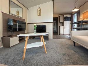 a living room with a table and a couch at The Fern caravan 17 in Angus