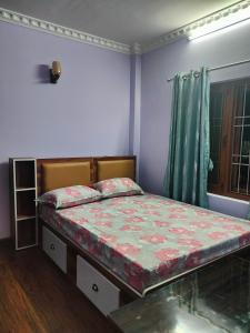 a bedroom with a bed in a room with a window at Durbar Home Apartments in Tribhuwan Airport