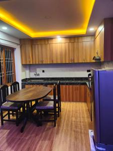 a kitchen with a wooden table and chairs and a counter at Durbar Home Apartments in Tribhuwan Airport