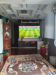 a living room with a tv with a soccer game on the screen at Durbar Home Apartments in Tribhuwan Airport